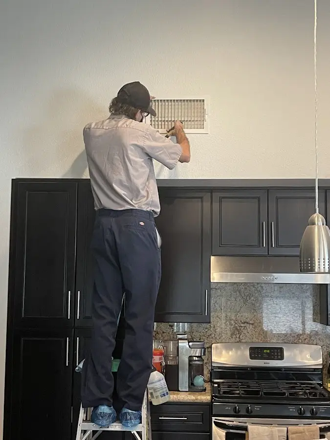 Technician inspecting an air vent during HVAC service in Star